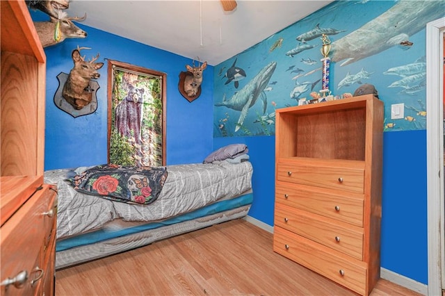 bedroom with wood finished floors, a ceiling fan, and baseboards