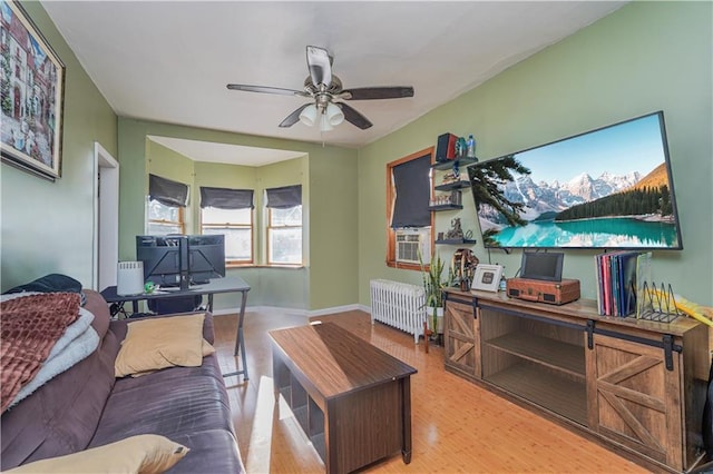 living room with baseboards, radiator heating unit, a ceiling fan, and wood finished floors