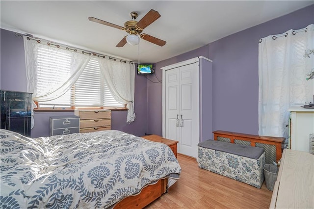 bedroom featuring a closet, wood finished floors, and a ceiling fan