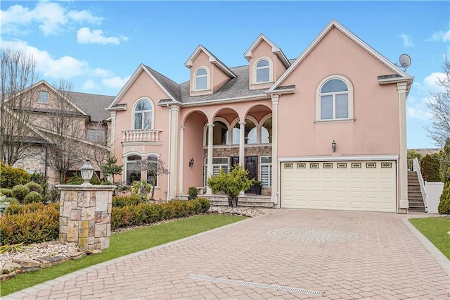 90 Giegerich Ave, Staten Island, NY 10307 - view of front facade featuring an attached garage, decorative driveway, stucco siding, and a porch