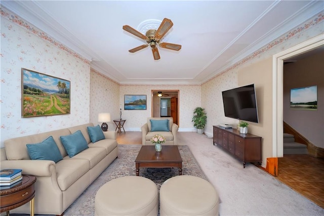 carpeted living room with ceiling fan, ornamental molding, and wallpapered walls