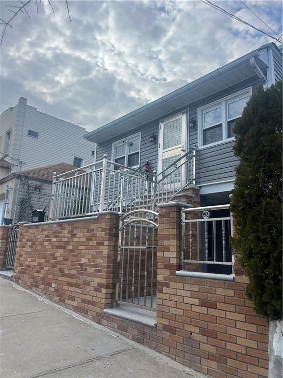 view of front of property featuring a gate, brick siding, and a fenced front yard