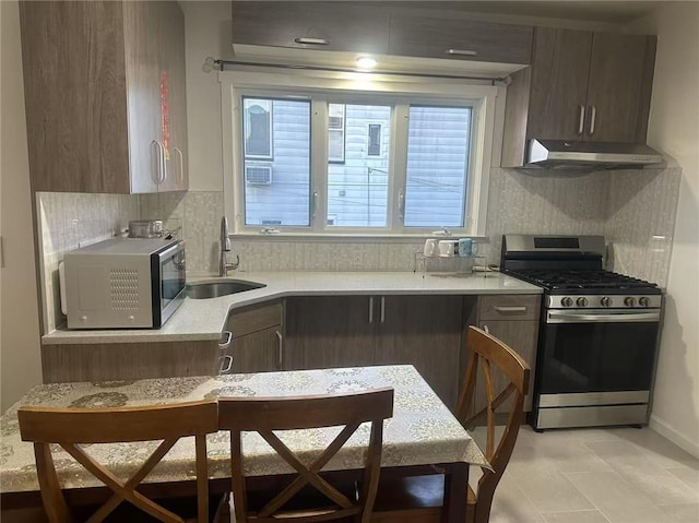 295 Clifton St, Staten Island, NY 10305 - kitchen with appliances with stainless steel finishes, a sink, under cabinet range hood, light countertops, and backsplash