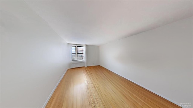 unfurnished room featuring light wood finished floors and baseboards