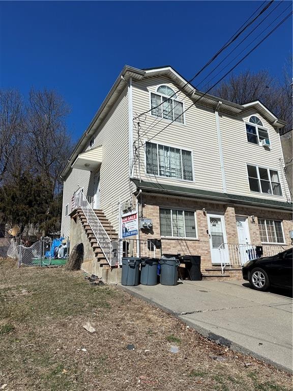 view of front of home featuring stairs and brick siding