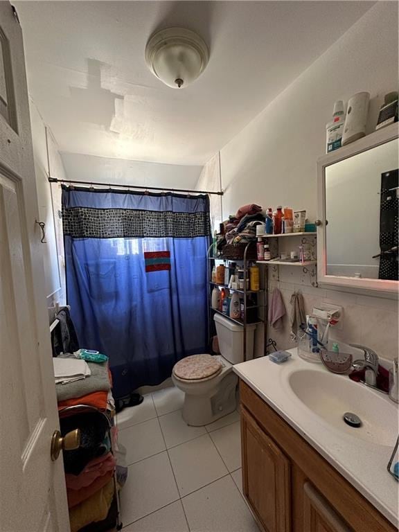 bathroom featuring tile patterned flooring, a shower with curtain, toilet, and vanity