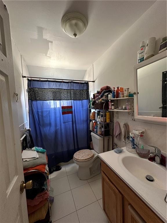 bathroom with tile patterned flooring, curtained shower, toilet, and vanity