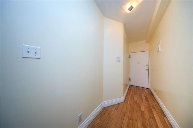 hallway with baseboards and light wood finished floors