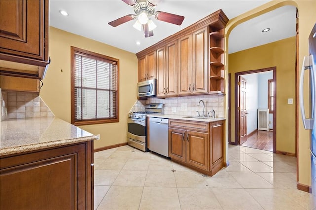 kitchen featuring light tile patterned floors, baseboards, open shelves, a sink, and stainless steel appliances