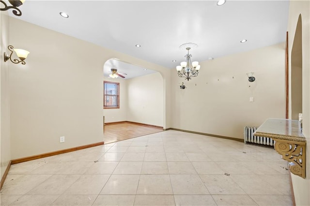 spare room with recessed lighting, baseboards, arched walkways, and radiator