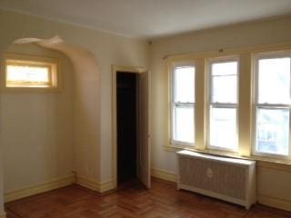 empty room featuring baseboards and radiator