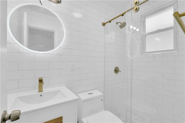 full bath featuring tile walls, a stall shower, toilet, and vanity