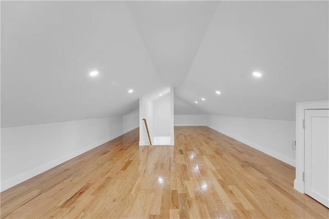 bonus room featuring vaulted ceiling, baseboards, and light wood finished floors