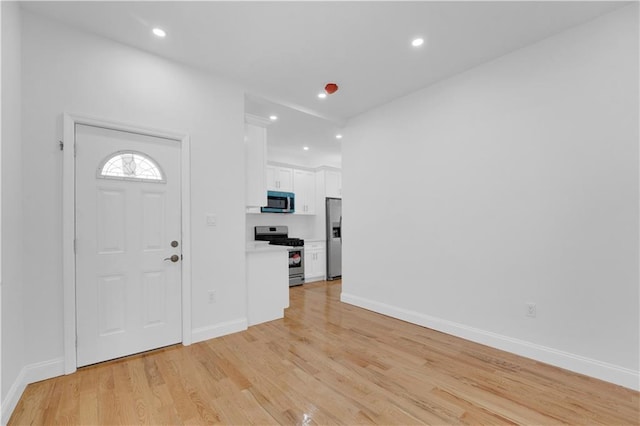 foyer entrance featuring recessed lighting, baseboards, and light wood-style floors