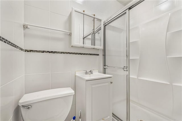 full bathroom featuring vanity, tile walls, toilet, and a stall shower