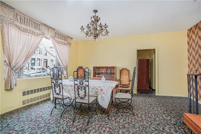 carpeted dining space with a notable chandelier, radiator, and baseboards