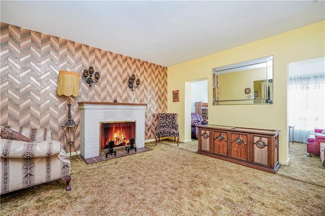 living room featuring baseboards, a fireplace with flush hearth, and carpet floors