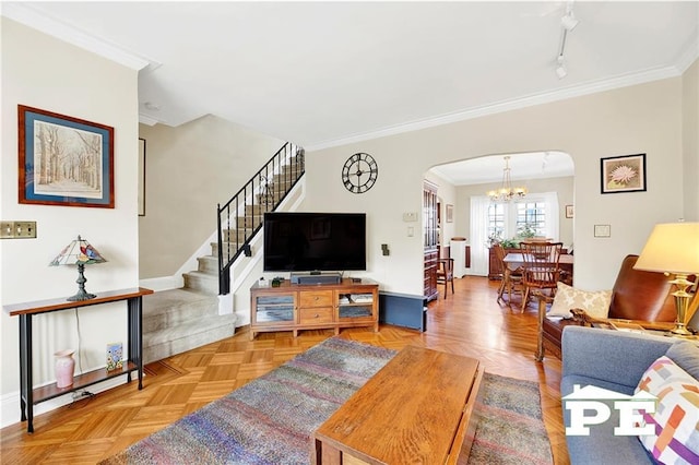 living area featuring arched walkways, an inviting chandelier, ornamental molding, and stairs