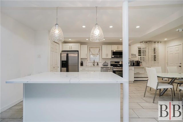 kitchen with a sink, backsplash, white cabinetry, appliances with stainless steel finishes, and a baseboard radiator