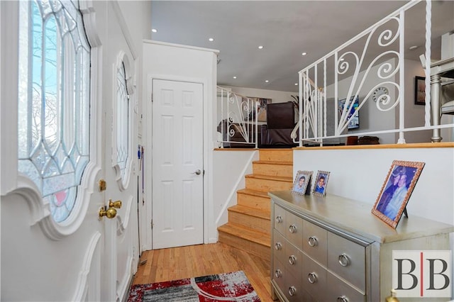 foyer entrance with stairs, recessed lighting, and light wood-type flooring