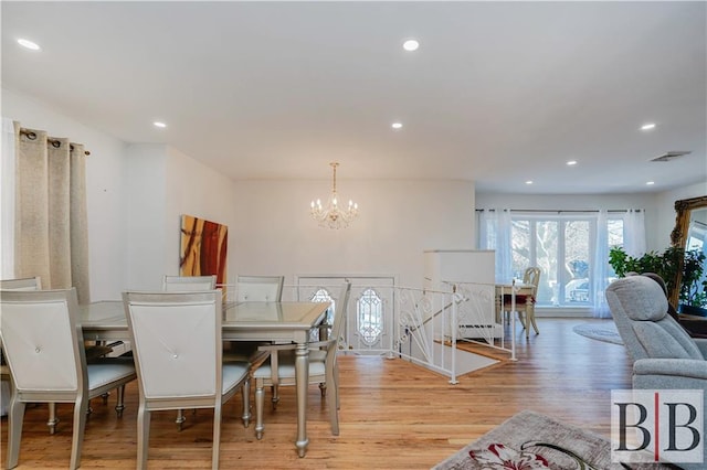 dining space featuring visible vents, light wood-type flooring, recessed lighting, a notable chandelier, and a baseboard radiator