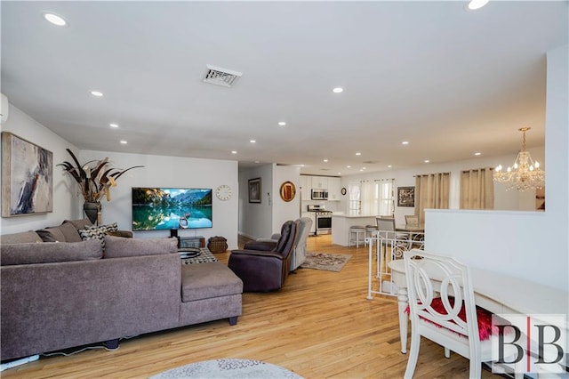 living area featuring light wood-style flooring, recessed lighting, and visible vents