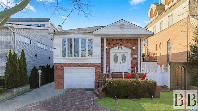 view of front of home featuring brick siding, driveway, an attached garage, and fence