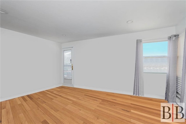 empty room featuring baseboards and light wood-style floors