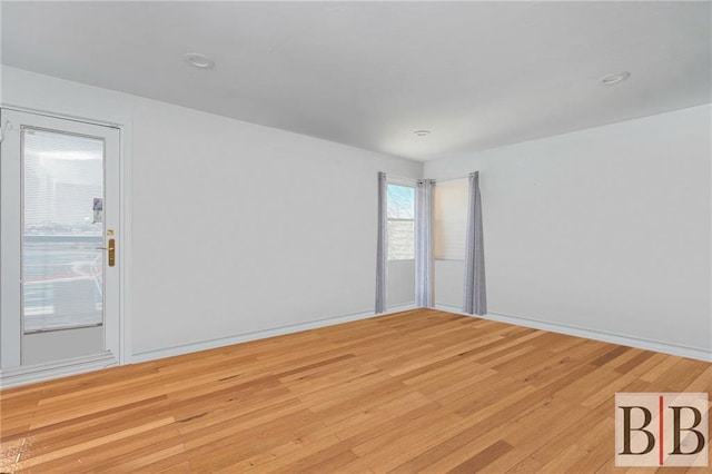 unfurnished room with light wood-style flooring and baseboards