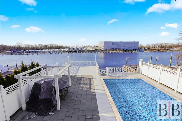 view of pool featuring fence and a water view