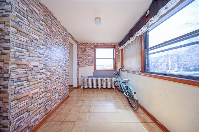 unfurnished bedroom featuring light tile patterned floors, radiator, and baseboards