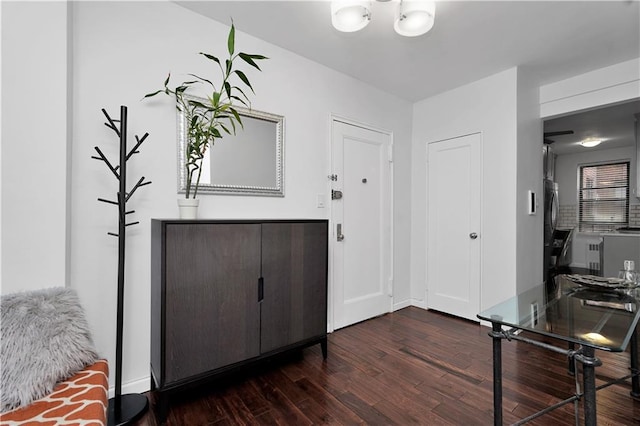 foyer entrance with dark wood finished floors and baseboards