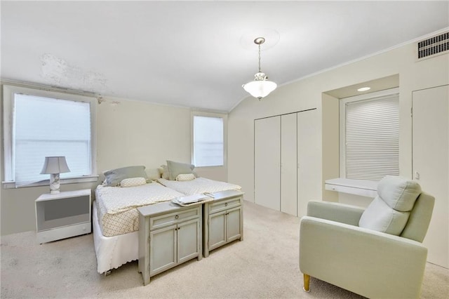 bedroom featuring light carpet, visible vents, lofted ceiling, and ornamental molding