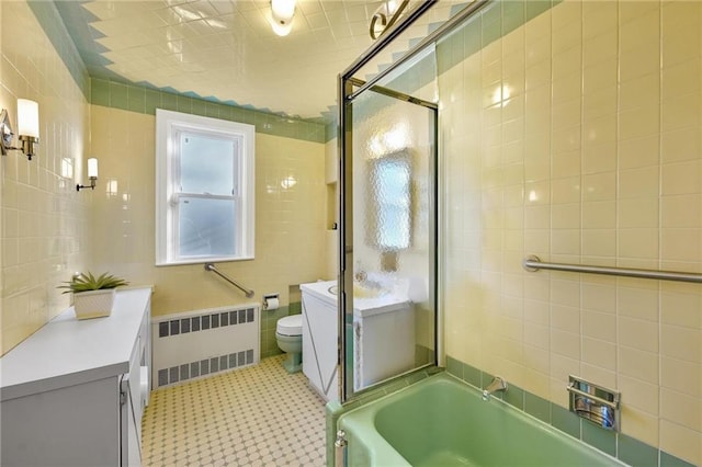 full bathroom with toilet, tile walls, radiator, and a bathtub