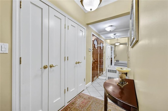 corridor featuring radiator heating unit and light tile patterned floors