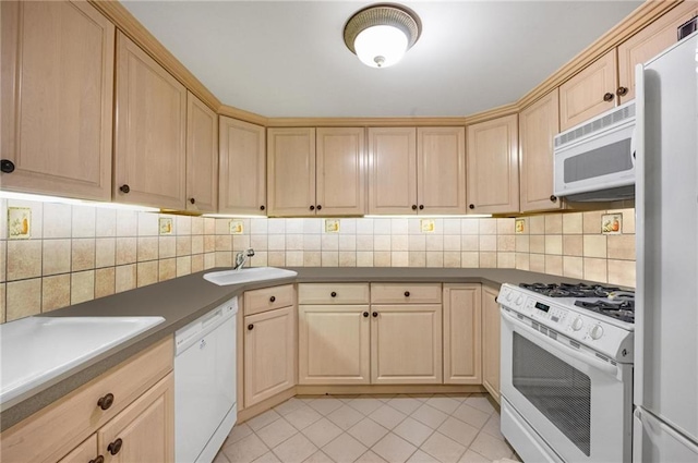 kitchen featuring tasteful backsplash, light brown cabinets, white appliances, and a sink