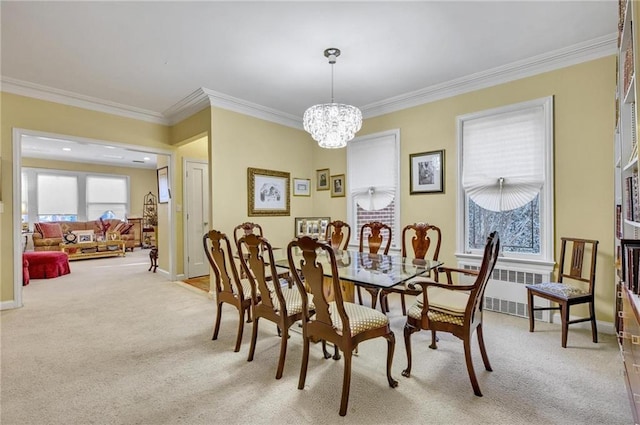 dining room featuring an inviting chandelier, ornamental molding, baseboards, and light carpet