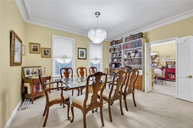 dining room featuring light colored carpet, baseboards, a notable chandelier, and ornamental molding