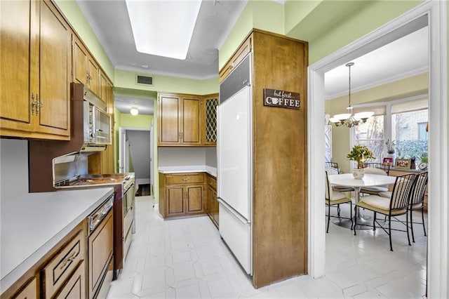 kitchen with visible vents, light countertops, brown cabinetry, a notable chandelier, and white appliances