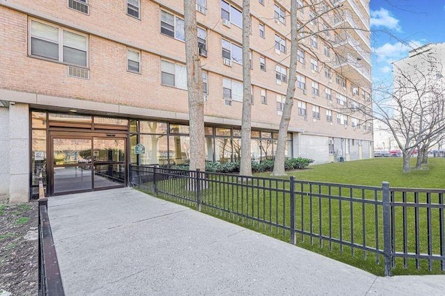 view of community with a lawn and fence