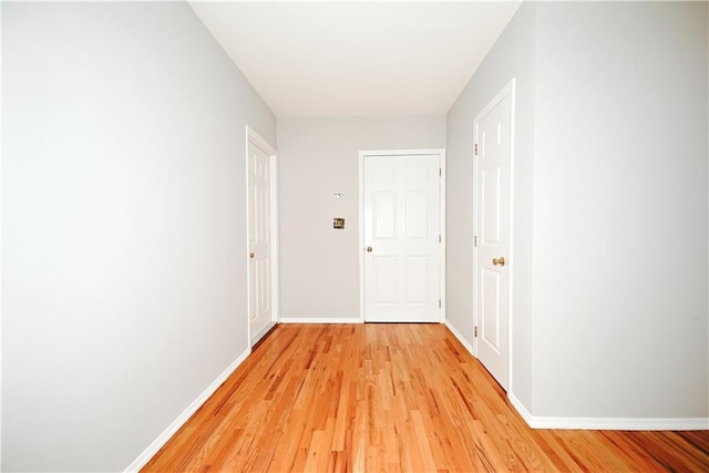 hallway featuring baseboards and light wood-style floors