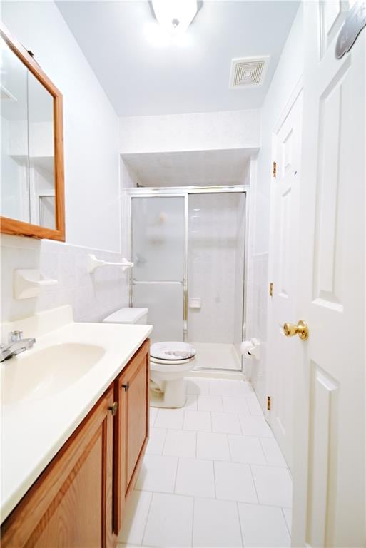 bathroom featuring vanity, toilet, visible vents, and a stall shower