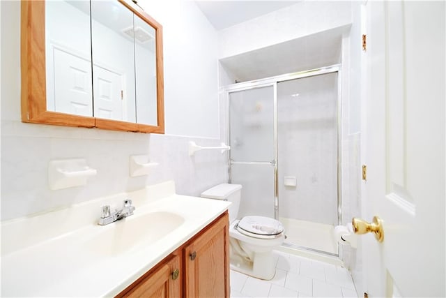 bathroom with vanity, a shower stall, toilet, and tile patterned floors