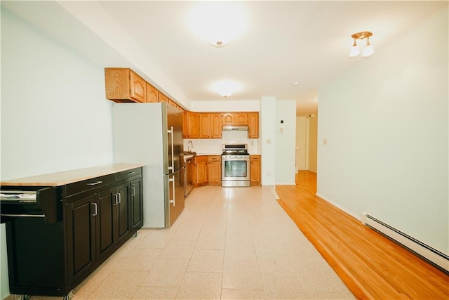 kitchen with stainless steel appliances, light countertops, under cabinet range hood, dark cabinets, and baseboard heating