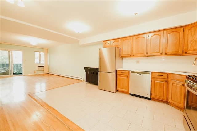 kitchen featuring a wall mounted air conditioner, a sink, a baseboard heating unit, stainless steel appliances, and light countertops