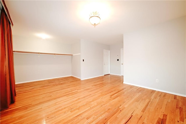 spare room featuring baseboards and light wood finished floors