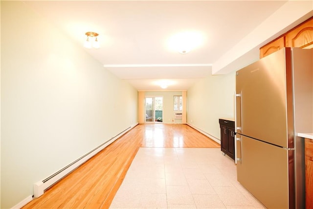 spare room with light wood-type flooring and a baseboard radiator