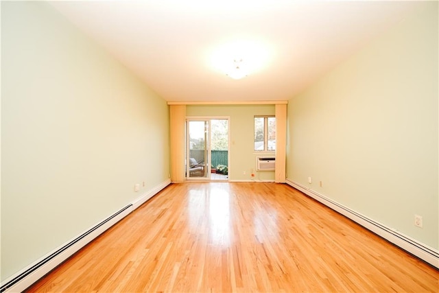 empty room featuring a baseboard radiator, baseboard heating, and light wood-style flooring