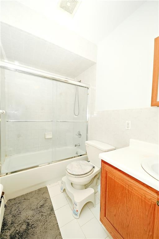 bathroom with tile patterned flooring, visible vents, vanity, and shower / bath combination with glass door