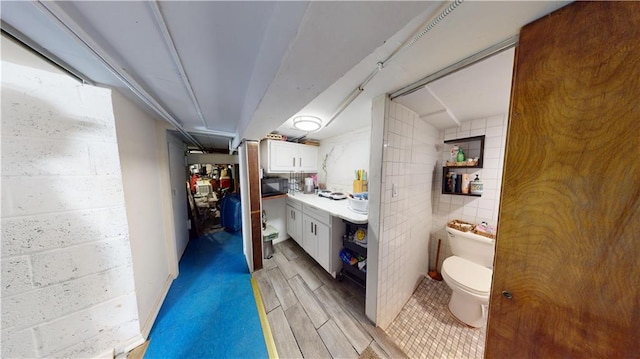 bathroom with wood tiled floor, toilet, and vanity